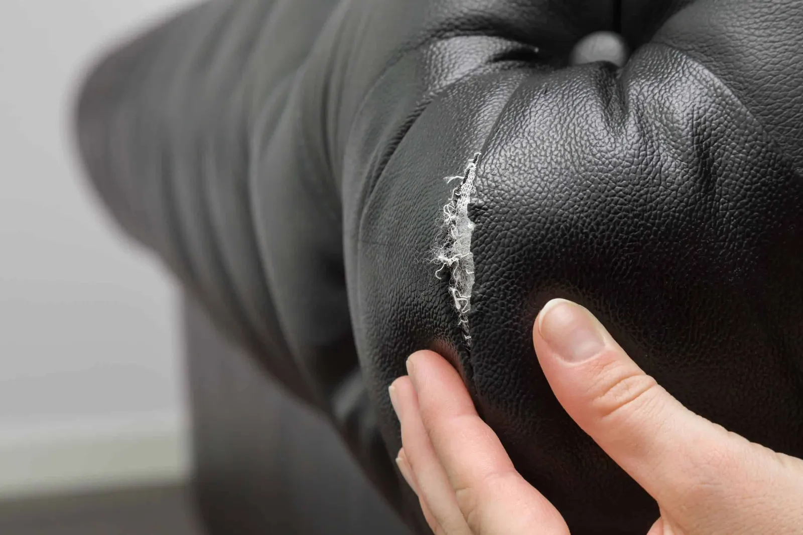 Torn leather sofa needing upholstery repair